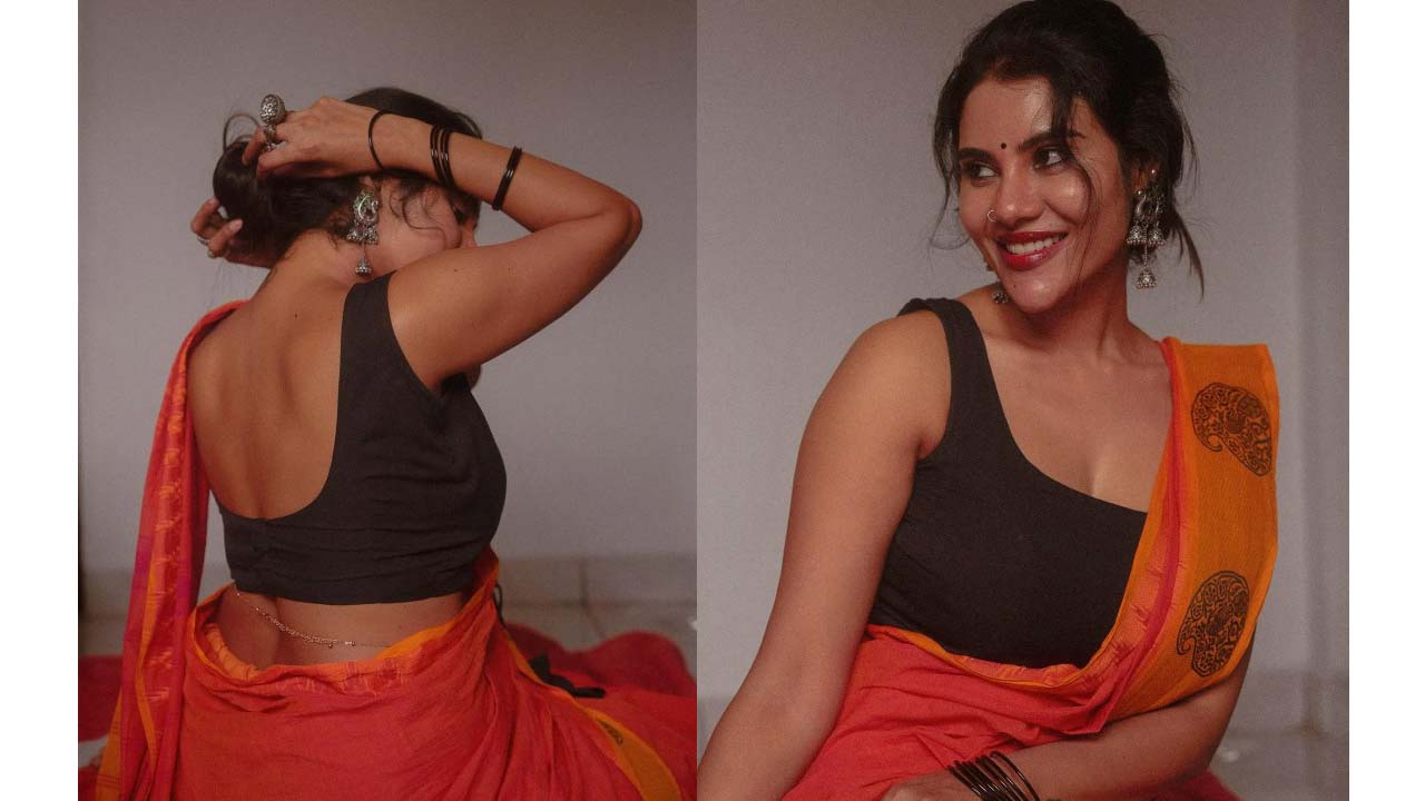 Nivisha exposing her dusky back navel in saree..